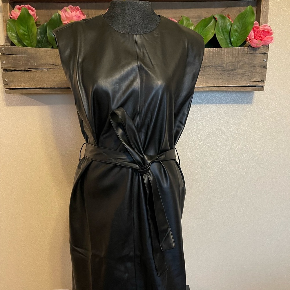 Faux leather mini dress by Bohme. Shoulder pad accents and belted waist.